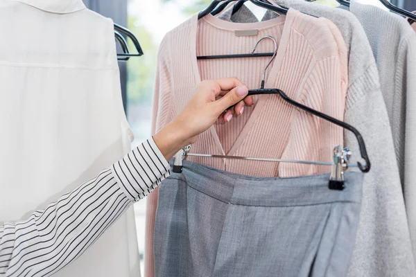 Mujer la elección de la ropa en sala de exposición - foto de stock