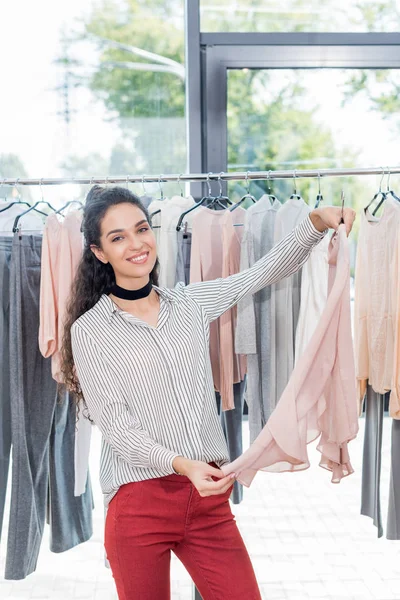 Mujer la elección de la ropa en sala de exposición - foto de stock