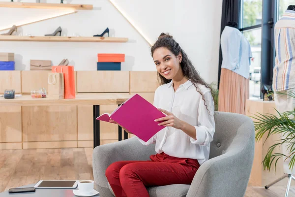 Woman reading magazine in showroom — Stock Photo