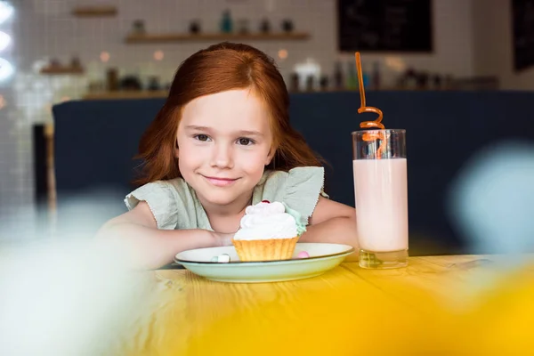 Fille avec cupcake et milk-shake dans le café — Photo de stock