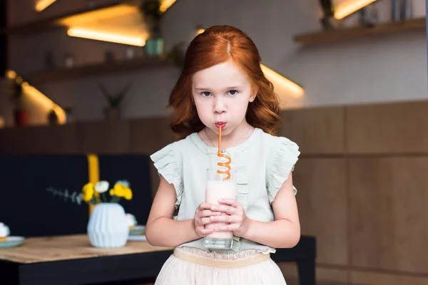 Girl drinking milkshake in cafe — Stock Photo
