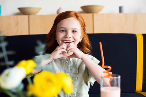 Girl showing hand heart symbol — Stock Photo