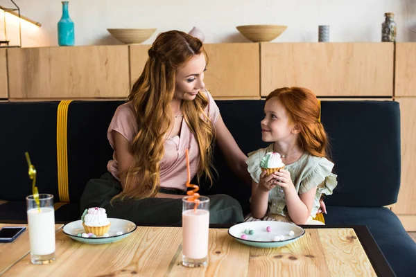 Mãe e filha comendo cupcakes — Fotografia de Stock