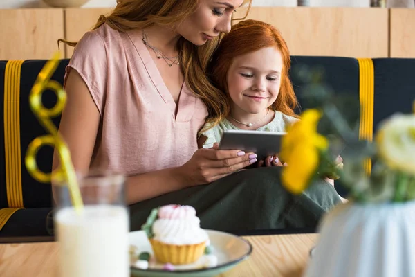 Mère et fille avec tablette numérique dans le café — Photo de stock