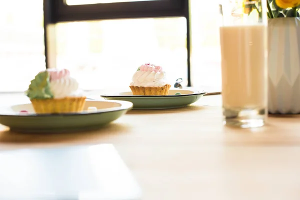 Milkshake and cupcakes on table — Stock Photo