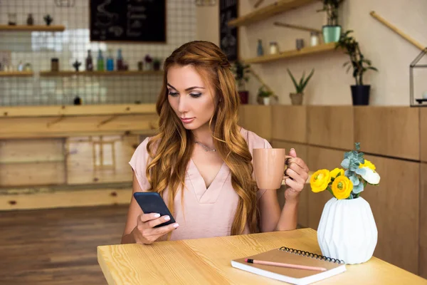 Mujer usando smartphone en la cafetería - foto de stock
