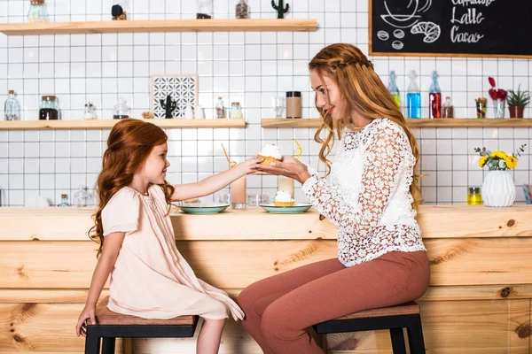 Mãe e filha segurando cupcake — Fotografia de Stock