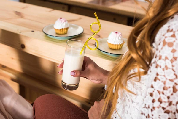 Женщина пьет молочный коктейль в кафе — стоковое фото