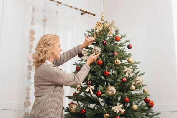 Woman decorating christmas tree — Stock Photo
