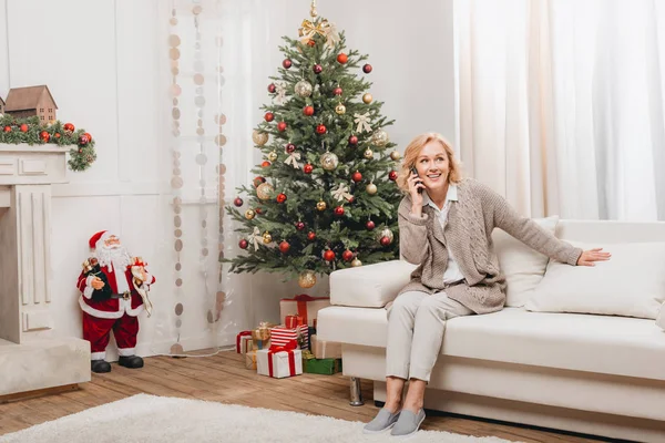 Woman talking on smartphone near christmas tree — Stock Photo