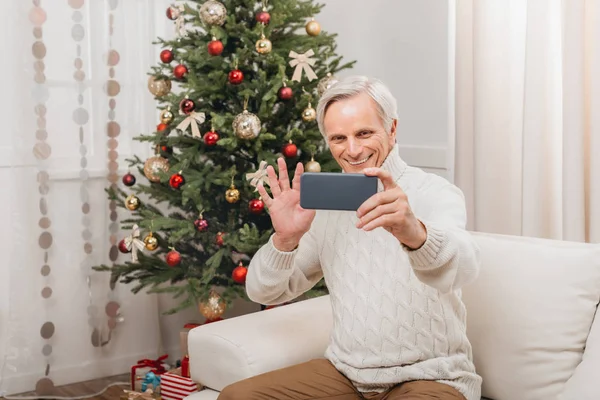 Man taking selfie with christmas tree — Stock Photo