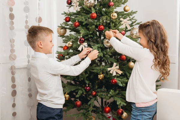Kids decorating christmas tree — Stock Photo