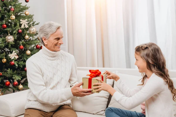 Großvater überreicht Geschenk an Enkelin — Stockfoto