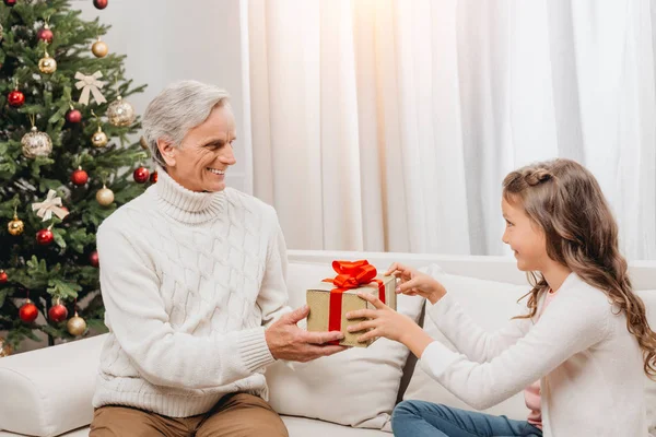 Grand-père présente un cadeau à sa petite-fille — Photo de stock