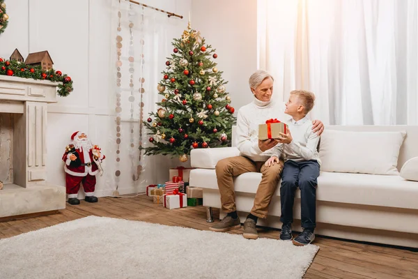 Großvater überreicht Weihnachtsgeschenk an Enkel — Stockfoto