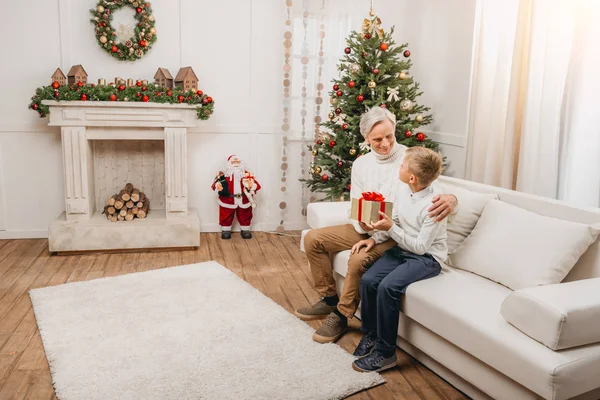 Großvater überreicht Weihnachtsgeschenk an Enkel — Stockfoto