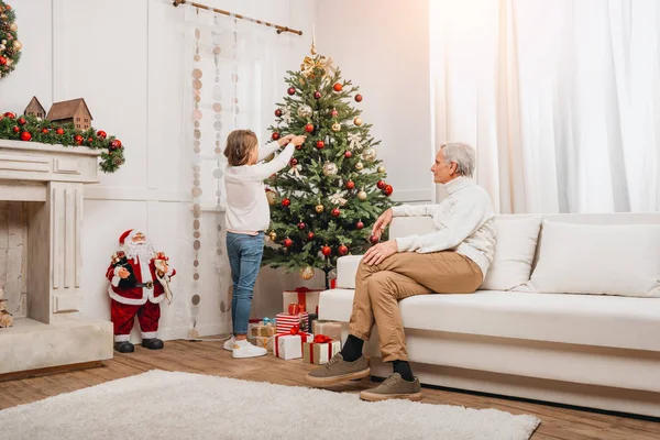 Grandfather and granddaughter decorating christmas tree — Stock Photo