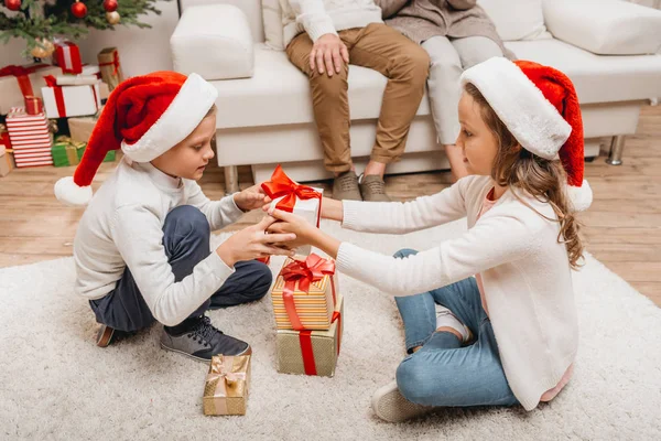 Petite fille présentant cadeau au garçon — Photo de stock