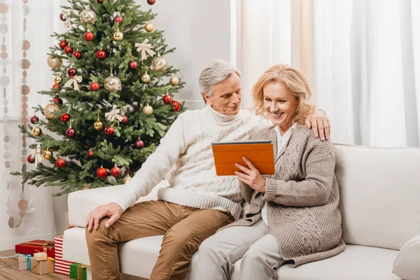 Старший мужчина и женщина с помощью планшета — стоковое фото