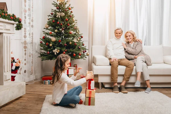 Grandparents and granddaughter with gift boxes — Stock Photo