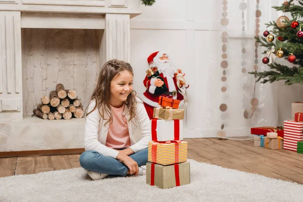 Kid with stack of christmas gifts — Stock Photo