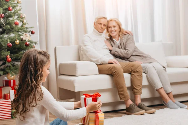 Grandparents and granddaughter with gift boxes — Stock Photo