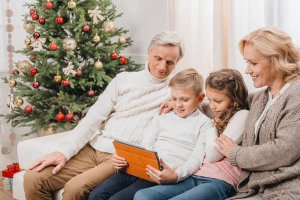 Abuelos y niños con tableta - foto de stock