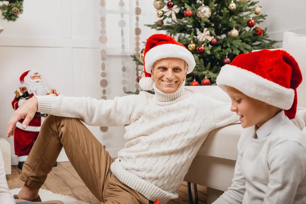 Grandfather and grandson in santa hats — Stock Photo