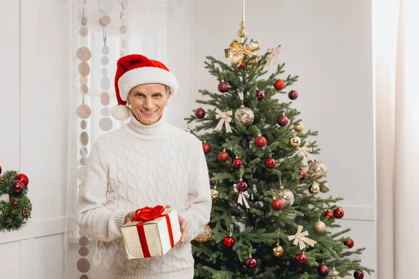 Senior man with christmas gift — Stock Photo