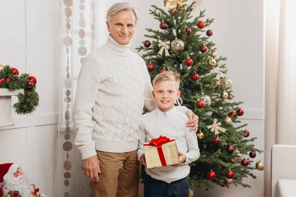 Дідусь і онук з різдвяним подарунком — стокове фото