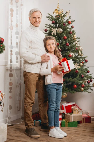 Abuelo y nieta con regalo de Navidad - foto de stock