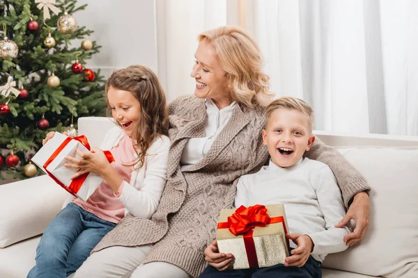 Mujer y niños con regalos de Navidad - foto de stock