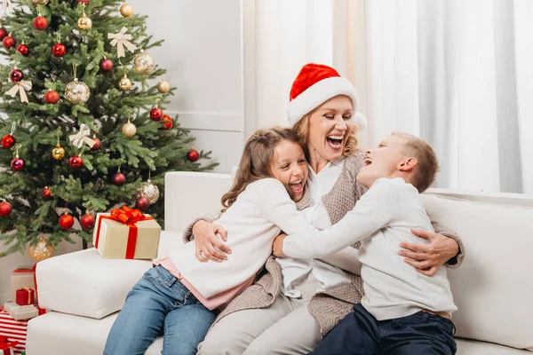 Mujer y niños en la habitación decorada de Navidad - foto de stock