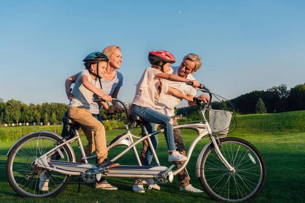 Бабушки и дедушки помогают детям ездить на велосипеде — стоковое фото