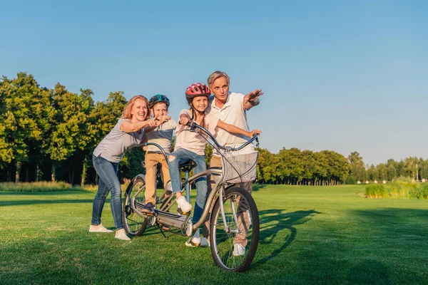 Grands-parents aider les enfants à faire du vélo — Photo de stock