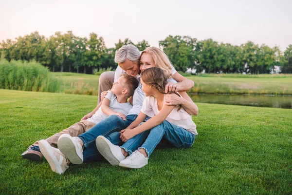 Familia descansando en el prado - foto de stock