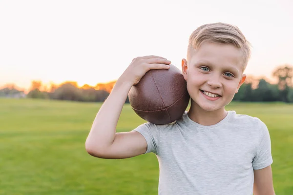 Enfant avec ballon de rugby dans le parc — Photo de stock
