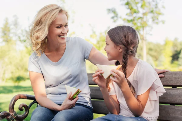 Woman and granddaughter eating sandwiches — Stock Photo