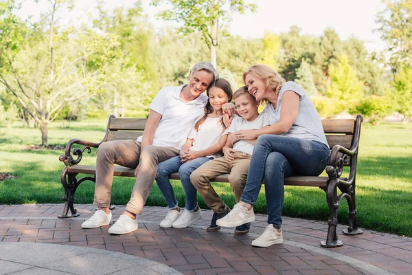 Famille se reposant ensemble dans le parc — Photo de stock