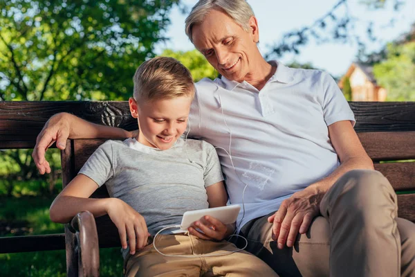 Familia con smartphone en el parque - foto de stock