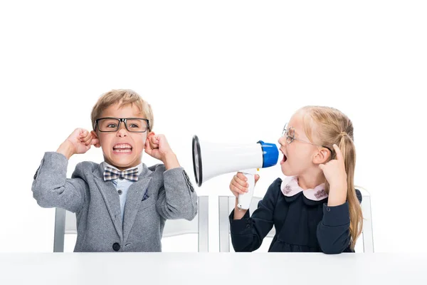 Schoolgirl shouting on boy with loudspeaker — Stock Photo