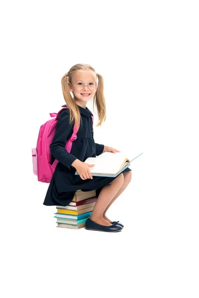 Schülerin sitzt auf Bücherstapel — Stockfoto