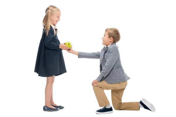 Schoolboy presenting apple to girl — Stock Photo