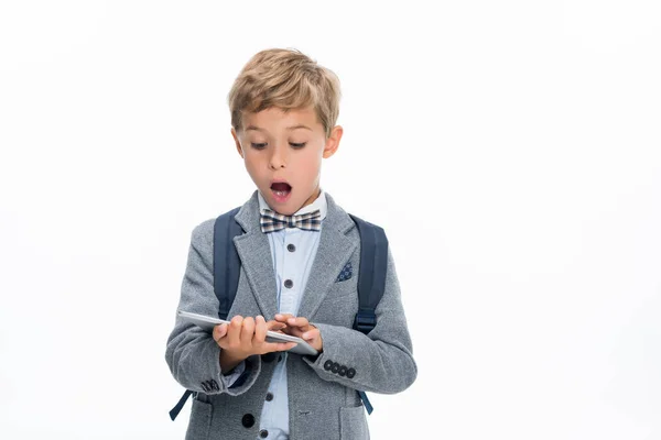 Shocked schoolboy using tablet — Stock Photo