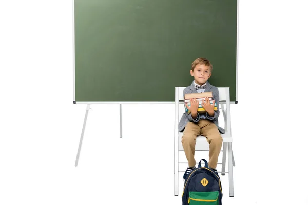 Colegial con pila de libros - foto de stock