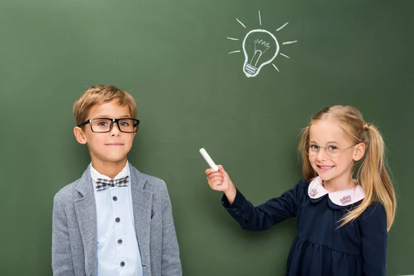 Beautiful pupils next to chalkboard — Stock Photo