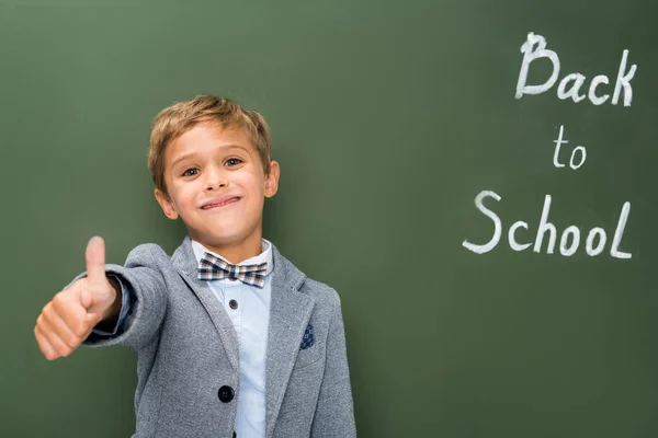 Schoolboy showing thumb up sign — Stock Photo