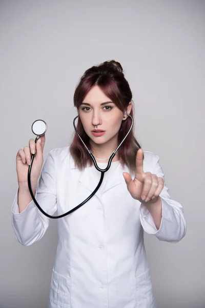 Jeune femme médecin tenant stéthoscope — Photo de stock