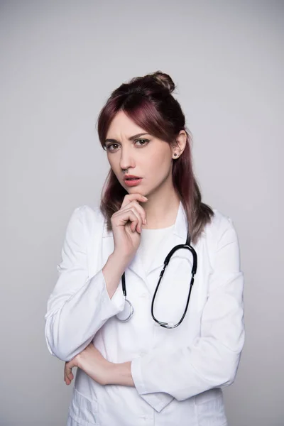 Young female doctor touching chin — Stock Photo