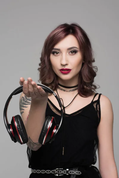 Young woman holding big headphones — Stock Photo